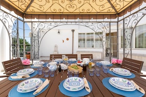 A table set for dining under a decorative metal canopy with a view of the cityscape. - 1916 Villa Virgilia by Perle di Puglia (Martina Franca)