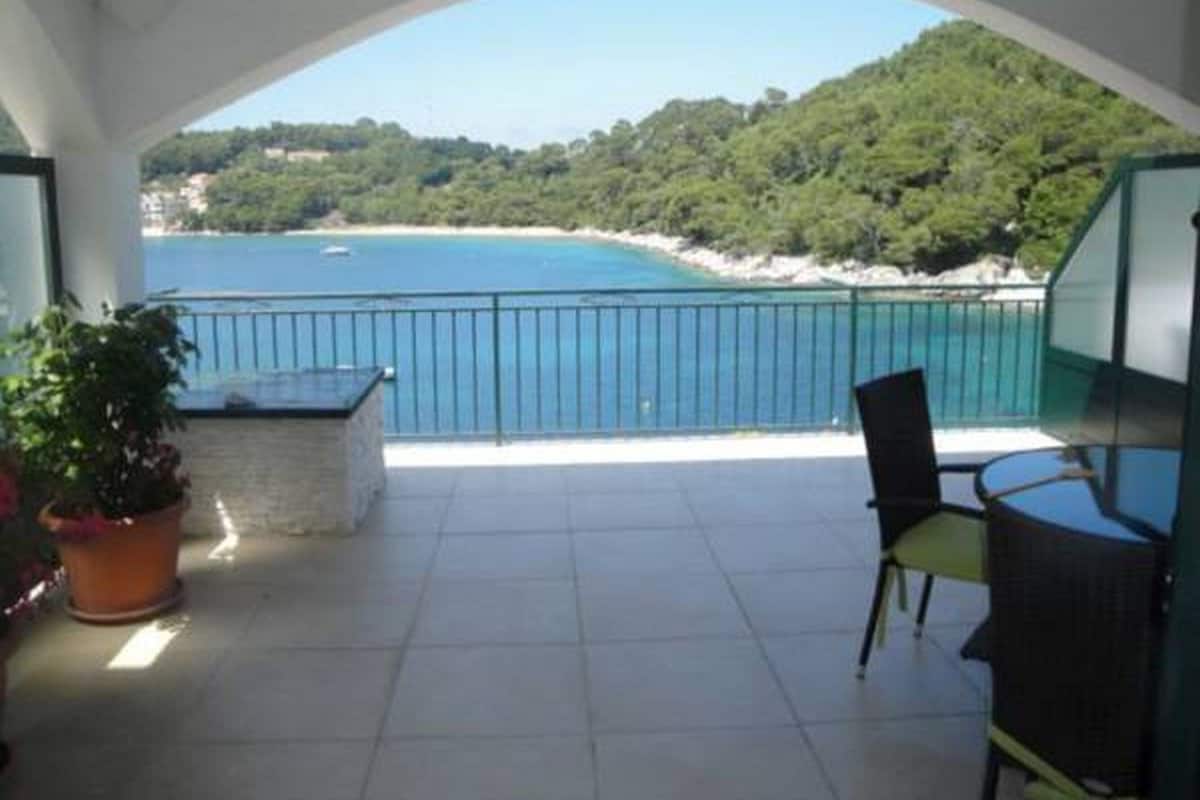 Ein Balkon mit Blick auf Strand und Meer.