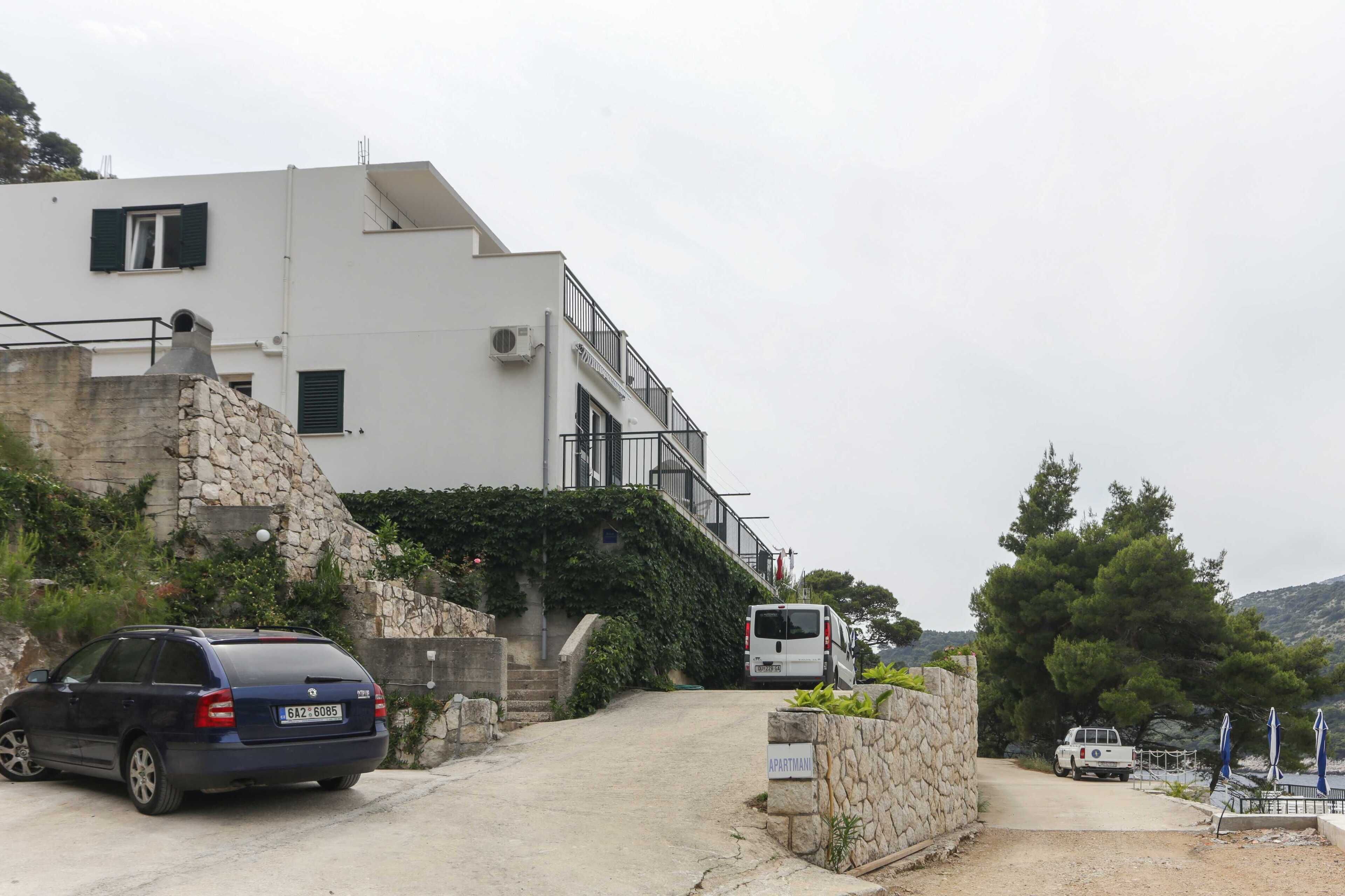 Un bâtiment moderne avec un mur en pierre et une voiture garée.