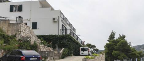 Un bâtiment moderne avec un mur en pierre et une voiture garée.