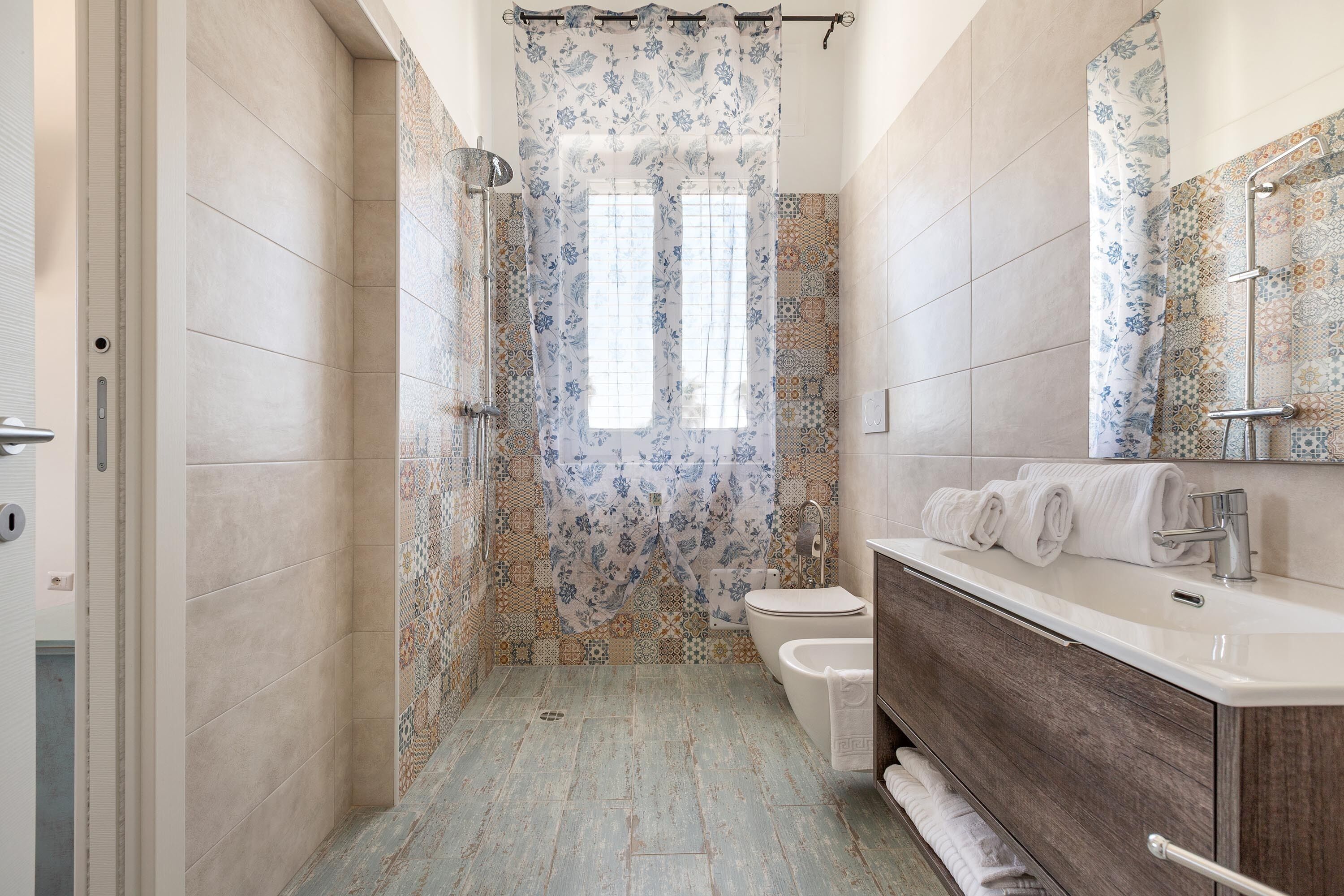 A bathroom with a shower, toilet, and vanity with a mirror.