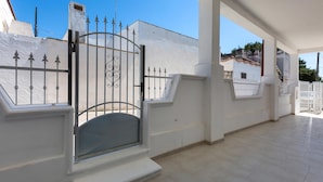 A covered outdoor area with a gated entrance, white walls, and a tiled floor. - 2934 Villetta Patrizia - Bilocale by Barbarhouse (Manduria)