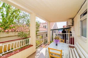 A balcony with a table and chairs, a railing, and potted plants. - Apartments Villa Molunat 1  (Konavle)