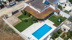 Luftaufnahme eines Wohnhauses mit Schwimmbad, Garten und Bootsanleger.