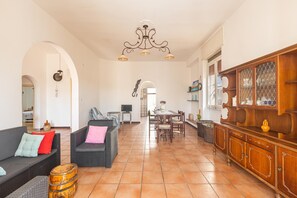 A spacious living area with a dining table, sofas, and a wooden cabinet. - 2961 Villa Poesia by Barbarhouse (Porto Cesareo)
