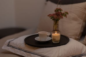 A white cup and a lit candle on a tray beside a pillow. - Impeccable 3-bed Duplex Penthouse in Saas-fee (Saas-Fee)
