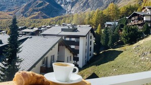 A mountain view with a house and a croissant on a table. - Impeccable 3-bed Duplex Penthouse in Saas-fee (Saas-Fee)