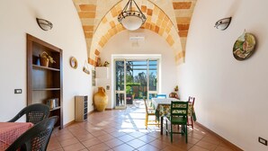 Uma ampla área de refeições com teto alto abobadado, uma janela grande e vista para o exterior.