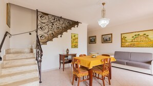 A dining area with a staircase, a chandelier, and artwork on the walls. - 2348 Villino Mareluce by Barbarhouse (Porto Cesareo)