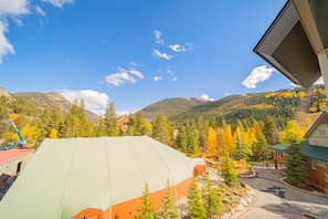 A view of a mountainous area with autumn foliage, a large tent-like structure, and a building with a green roof. - Silver Mill 8284 (Keystone)