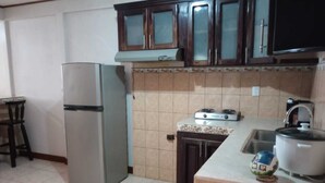 A kitchen with a refrigerator, stove, sink, and cabinets. - Limon's house in Limon center Costa Rica (Limón)