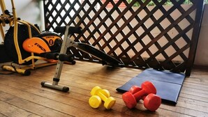 A home gym with a stationary bike, dumbbells, and a yoga mat. - Limon's house in Limon center Costa Rica (Limón)