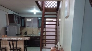 A kitchen with a dining area, a refrigerator, a sink, and a staircase leading to another level. - Limon's house in Limon center Costa Rica (Limón)