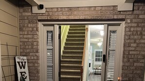 Un pasillo con una puerta de madera que da a una escalera.