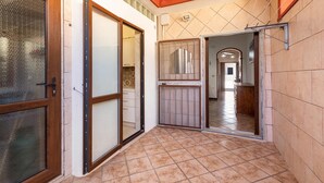 A hallway with tiled flooring, a wooden door with a glass panel, and a metal gate leading to another room. - 2669 Casa Ulbia by Barbarhouse (Manduria)