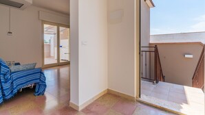 Ein Zimmer mit einem Bett, einem Fenster und einer Treppe, die in einen Außenbereich führt.