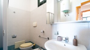 A small bathroom with a toilet, bidet, sink, and a mirror. - 2991 Villino Patrizia by Barbarhouse (Porto Cesareo)