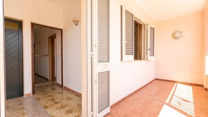 An interior corridor with a tiled floor, a door with a metal kick plate, and a wall-mounted light fixture. - 3021 Villa Seremar by Barbarhouse (Trepuzzi)