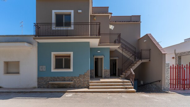 A two-story building with a balcony, a staircase, and a red gate. - 2952 Residence Flamingo - Appartamento Piccolo by Barbarhouse (Manduria)