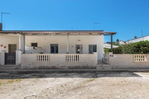 Ein zweigeschossiges Gebäude mit einem Ziegeldach, einem Balkon mit einer Brüstung und einem verschlossenen Eingang.