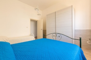 Quarto com cama grande, guarda-roupa e cadeira suspensa.
