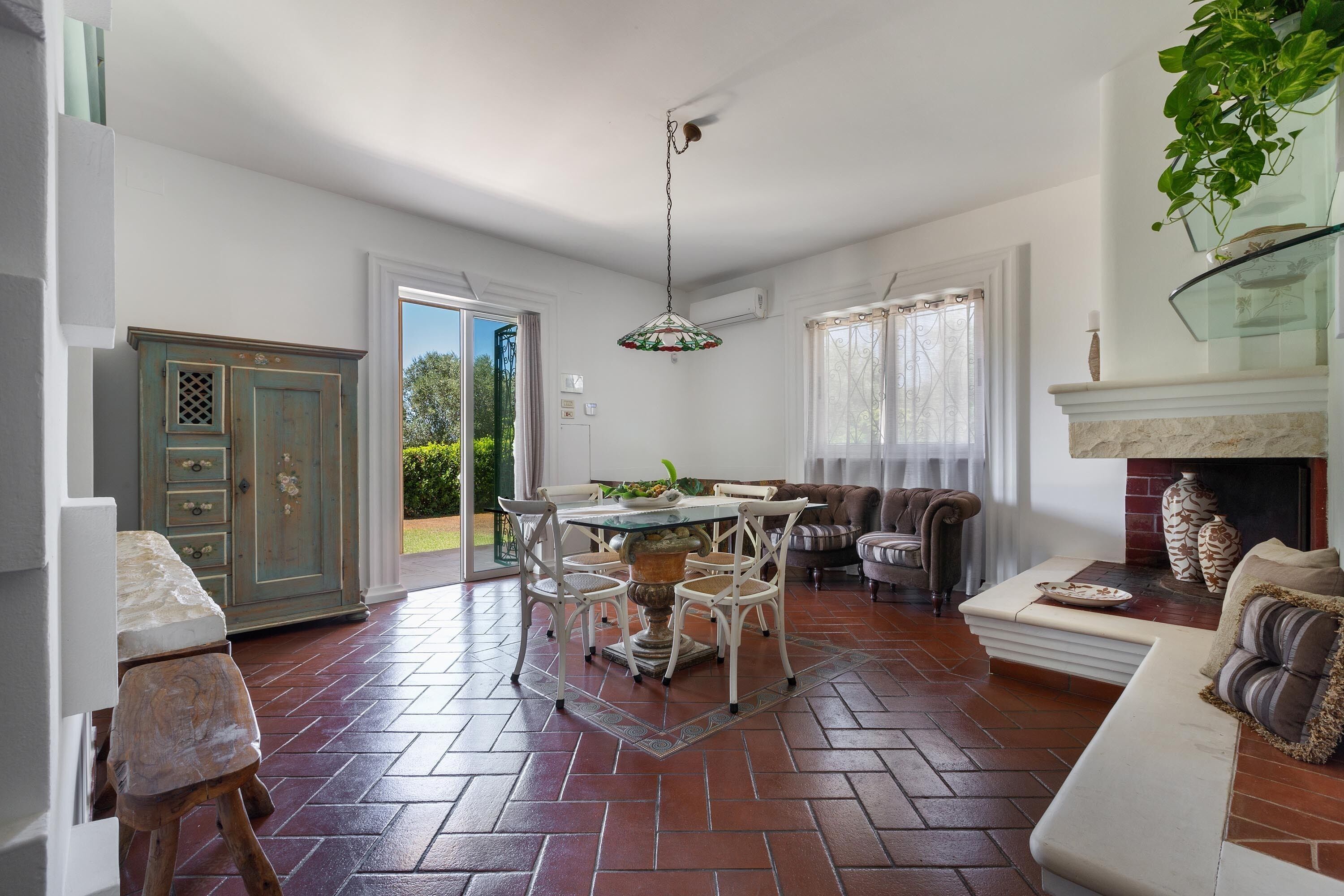 A spacious living area with a dining table, chairs, a sofa, and a fireplace.