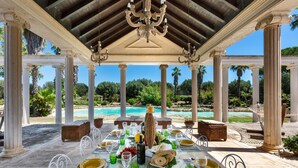 Ein Tisch, gedeckt für eine Mahlzeit, mit Blick auf einen Pool und Palmen.