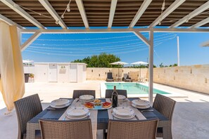 An outdoor dining area with a pool in the background. - 3047 Villetta Nicols by Barbarhouse (Torricella)