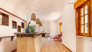 Eine geräumige Küche mit einer zentralen Kochinsel, Holzschränken und einem roten Stuhl.