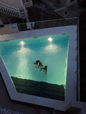 An indoor swimming pool with clear water, a view of the outside, and a staircase leading to an upper level. - Holiday apartment with sea views, air conditioning and pool (Karlobag)