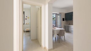A modern kitchen with white cabinets and a large window. - 2126 Villa Ippocampo - Appartamento Blu by Barbarhouse (Manduria)