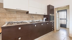 Eine moderne Küche mit einem Gasherd, einer Spüle und einem Einbauofen.