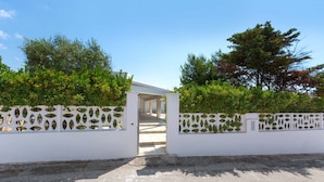 A gated entrance to a building with a white fence and decorative panels, leading to a covered walkway. - 3041 Villetta Sunshine by Barbarhouse (Manduria)