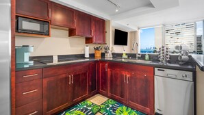 A modern kitchen with dark wood cabinets, a microwave, and a dishwasher.