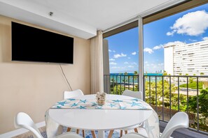 Enjoy ocean and city views from the balcony, featuring a dining table and seating area.
