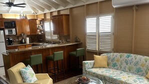 Een ruime woonkamer met een keuken, een eettafel en een bank.