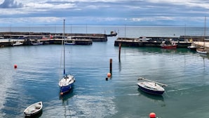 Een jachthaven met verschillende boten afgemeerd, kalm water en een heldere lucht.