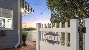 A wooden deck with a white gate labeled "LA PETITE". - New Tiny House (Camp Hill)