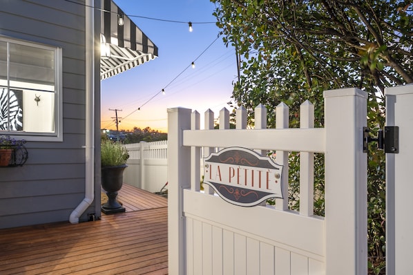A wooden deck with a white gate labeled "LA PETITE".
