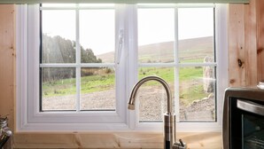 A kitchen with a window, a sink, and a stove.