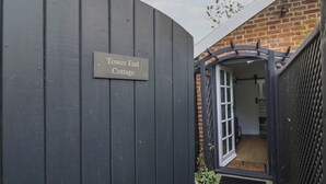 Una porta de fusta fosca amb un rètol que diu 'Tower End Cottage'.