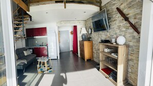 A modern interior with a staircase, a kitchen, a living area with a sofa, and a wooden shelf with glasses. - Small sugar bowl duplex with sea view (Cul de Sac)
