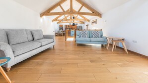 A spacious loft with high ceilings and exposed wooden beams. - Swallow Barn (Cockermouth)