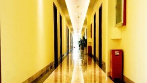 A long, well-lit hallway with a shiny floor, doors on both sides, and a red object on the right. - Duyun Star Boutique Hotel (Weinan Vocational and Technical College) (Duyun)