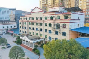 Un edificio de varios pisos con un patio central, rodeado de árboles y otros edificios.