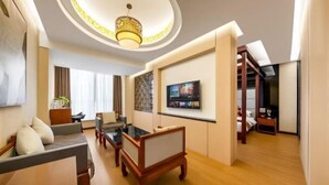 Een moderne woonkamer met een bank, salontafel en een televisie aan de wand.