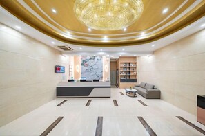 A hotel lobby with a reception desk, a chandelier, a sofa, and a bookshelf. - Huahuitong Hotel (Wujiang Shaoguan Station) (Shaoguan)