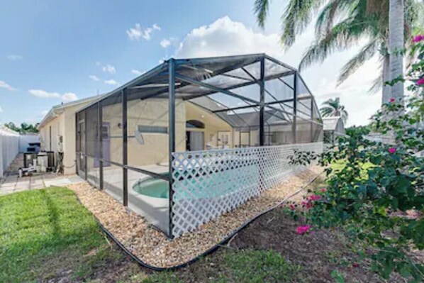Enjoy a patio with a glass-enclosed space, small pool, and lush surroundings.