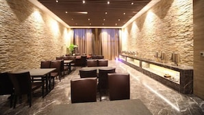 Eine moderne Lobby mit Steinwänden, einem Marmorboden und einer Rezeption mit Theke.