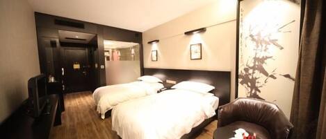 Ein Hotelzimmer mit einem Bett, einem Schreibtisch, einem Stuhl und einem kleinen Tisch mit Kerzen.
